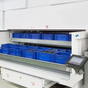 Automated storage system with blue plastic bins on sliding shelves, equipped with a touchscreen control panel, offering advanced warehouse solutions in an industrial setting.