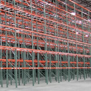 Empty industrial warehouse racking with green vertical supports and orange horizontal beams, arranged in rows under a high ceiling—ideal for businesses seeking efficient Warehouse Solutions.