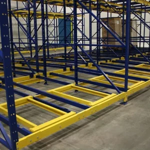 Blue and yellow industrial pallet racking system with rollers installed in a warehouse, designed for storing and moving pallets as part of efficient warehouse solutions.