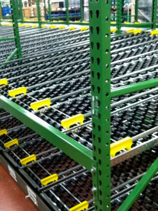 Green metal shelving unit with multiple roller tracks and yellow guides, designed for efficient warehouse storage and Carton Flow systems in automated material handling.