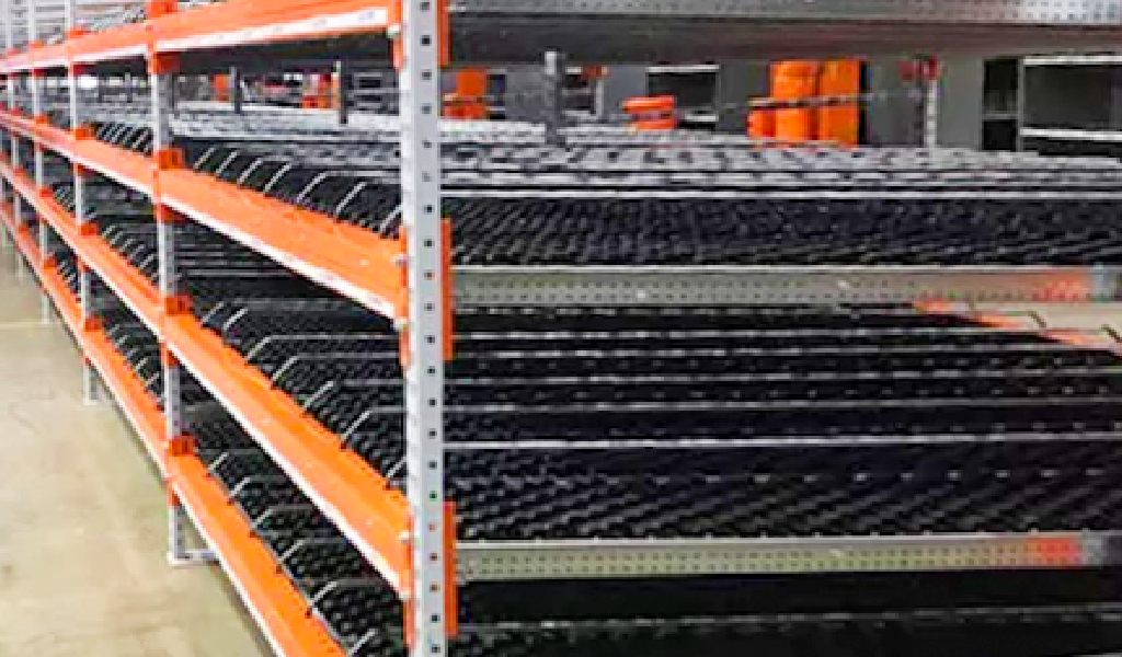 A rack with black and orange metal shelves, designed for efficient carton flow systems.