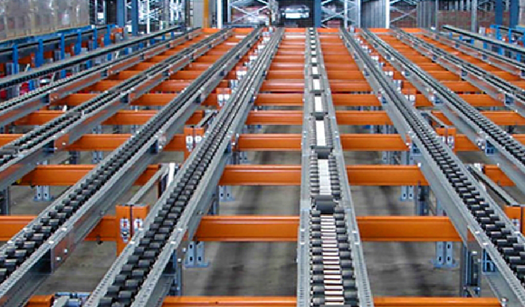 Close-up view of empty warehouse carton flow racking system with multiple metal rollers and orange support beams.