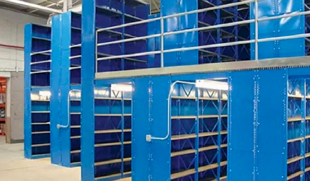 Blue industrial metal shelving units with multiple levels and railings are arranged in a warehouse or storage facility, standing empty and ready for use. These sturdy industrial shelving systems maximize space and organization.